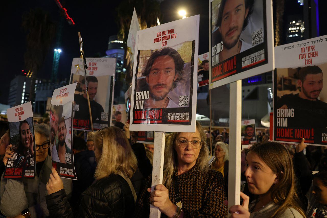 Relatives and supporters hold placards bearing portraits of Israeli hostages held in Gaza since the October 7 attacks by Hamas in southern Israel, during a rally calling for their release, in Tel Aviv on December 30, 2023. The placards (C) show Omer Shem Tov. (Photo by AHMAD GHARABLI / AFP)