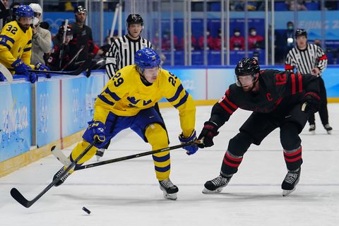 Sweden's Pontus Holmberg (29) chases the puck with Canada's Eric Staal (12) during a men's quarterfinal hockey game at the 2022 Winter Olympics, Wednesday, Feb. 16, 2022, in Beijing. (AP Photo/Matt Slocum)
