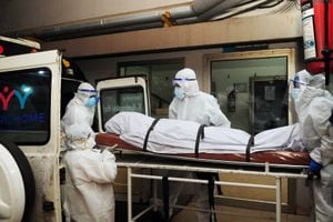 En esta fotografía tomada el 12 de septiembre de 2023, trabajadores sanitarios con equipo de protección mueven el cuerpo de una persona que murió a causa de una infección por el virus Nipah en un hospital privado de Kozikode, en el estado indio de Kerala. (Foto de AFP)