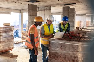 Ingeniero, arquitecto y hombre de negocios trabajando en el proyecto de ingeniería en el sitio de construcción. Concepto de construcción de viviendas. Foto de un joven ingeniero arquitecto usando una computadora portátil.