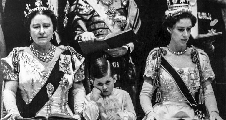 Carlos, de 4 años, durante la coronación de su madre, Isabel II, en 1953, junto a su abuela, la reina madre, y su tía, la princesa Margarita.