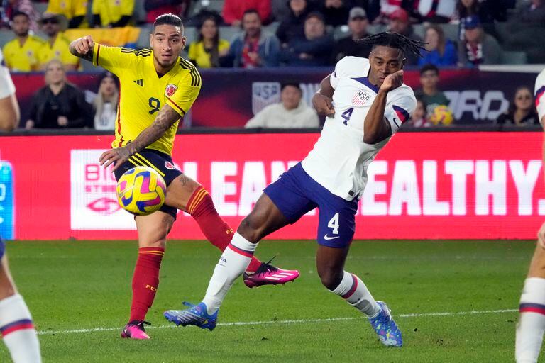 Colombia's Cristian Arango, left, takes a shot on goal next to United States' DeJuan Jones during the first half of an international friendly soccer match Saturday, Jan. 28, 2023, in Carson, Calif. (AP Photo/Marcio Jose Sanchez)