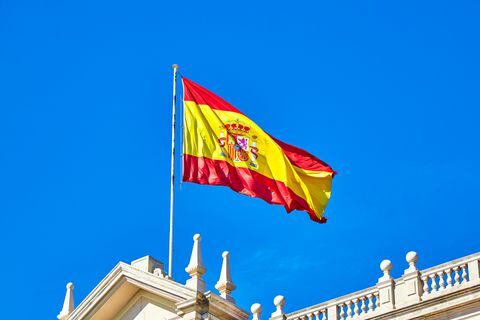 The Spanish flag flying on top of building roof, Spain.