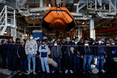 Migrantes a bordo del barco de rescate Geo Barents, operado por Médicos Sin Fronteras, esperan su llegada a Bari, Italia, el 26 de marzo de 2023
