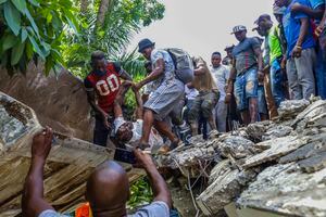 La gente recupera el cuerpo de Jean Gabriel Fortune, un legislador a largo plazo y ex alcalde de Les Cayes, desde los escombros del Hotel Le Manguier destruido por el terremoto en Les Cayes, Haití, sábado, 14 de agosto de 2021. Un terremoto de magnitud 7.2 Haití el sábado, con el epicentro a unos 125 kilómetros (78 millas) al oeste de la capital de Port-Au-Prince, dijo la encuesta geológica de los Estados Unidos. (AP Foto / Ralph Tedy Erol)