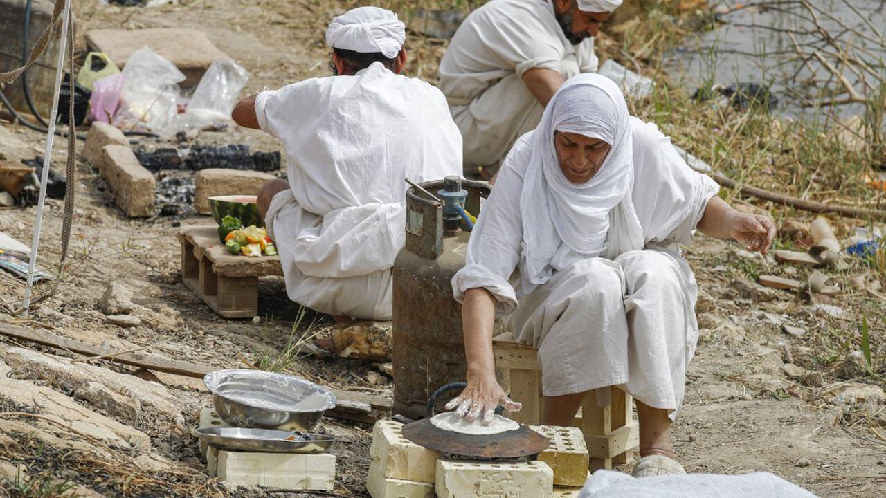 Los seguidores de la fe precristiana de Sabaean, que considera al profeta Abraham como uno de sus fundadores, hornean pan y cocinan a orillas del río Tigris en la capital de Irak, Bagdad, el 15 de marzo de 2022.