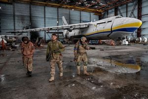 Los miembros del servicio ucraniano se paran frente a un avión Antonov An-124 Ruslan, destruido por las tropas rusas mientras continúa el ataque de Rusia contra Ucrania, en un aeródromo en el asentamiento de Hostomel, en la región de Kiev, Ucrania, el 3 de abril de 2022. Foto REUTERS/Gleb Garanich