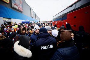 La policía maneja a las personas mientras esperan para abordar un autobús, en un centro de alojamiento temporal, después de huir de la invasión rusa de Ucrania, en Korczowa, Polonia, el 6 de marzo de 2022. Foto REUTERS/Yara Nardi