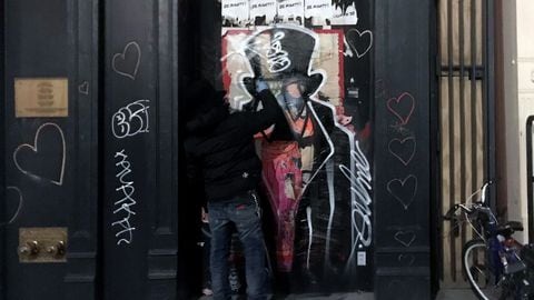 El artista urbano "Saynosleep" pintando la puerta de un edificio en Nueva York. Diciembre de 2020. Foto: Thomas Urbain / AFP