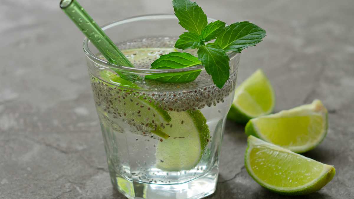 Glass of water with chia seeds and lime on a gray background. A healthy drink for weight loss.