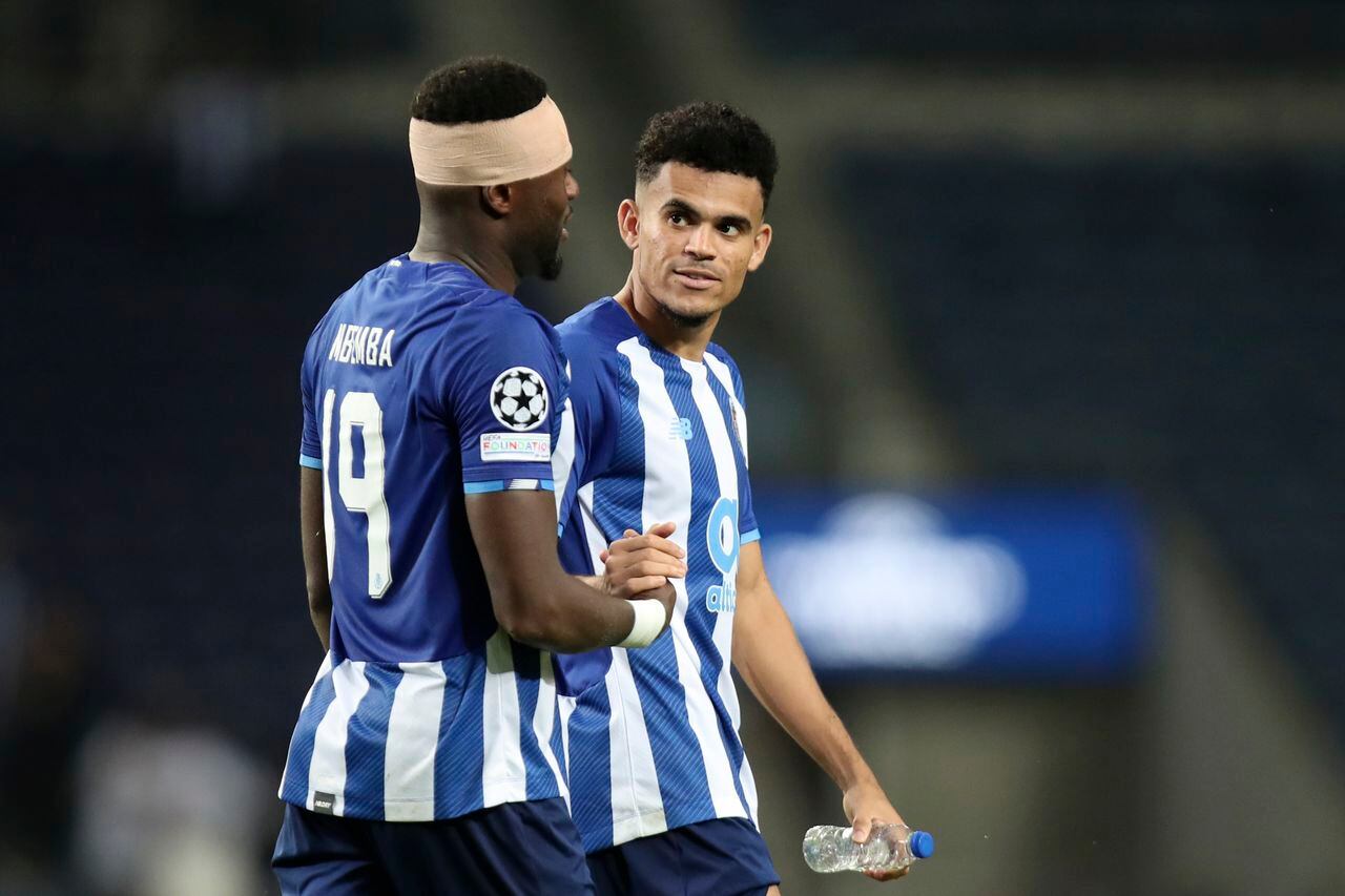 Porto's Luis Diaz shakes hands with Chancel Mbemba, left, at the end of the Champions League group B soccer match between FC Porto and AC Milan at the Dragao stadium in Porto, Portugal, Tuesday, Oct. 19, 2021. Diaz scored the goal in Porto's 1-0 win. (AP Photo/Luis Vieira)