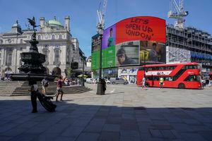 La gente camina en Piccadilly Circus, en Londres. Se espera que el primer ministro británico, Boris Johnson, confirme el lunes que la próxima relajación planificada de las restricciones del coronavirus en Inglaterra se retrasará como resultado de la propagación de la variante delta primero. identificado en la India. (Foto AP / Alberto Pezzali)