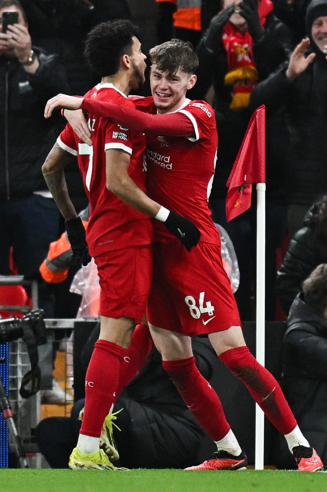 Liverpool's Northern Irish defender #84 Conor Bradley (R) celebrates with Liverpool's Colombian midfielder #07 Luis Diaz (L) after scoring his team second goal during the English Premier League football match between Liverpool and Chelsea at Anfield in Liverpool, north west England on January 31, 2024. (Photo by Paul ELLIS / AFP) / RESTRICTED TO EDITORIAL USE. No use with unauthorized audio, video, data, fixture lists, club/league logos or 'live' services. Online in-match use limited to 120 images. An additional 40 images may be used in extra time. No video emulation. Social media in-match use limited to 120 images. An additional 40 images may be used in extra time. No use in betting publications, games or single club/league/player publications. /