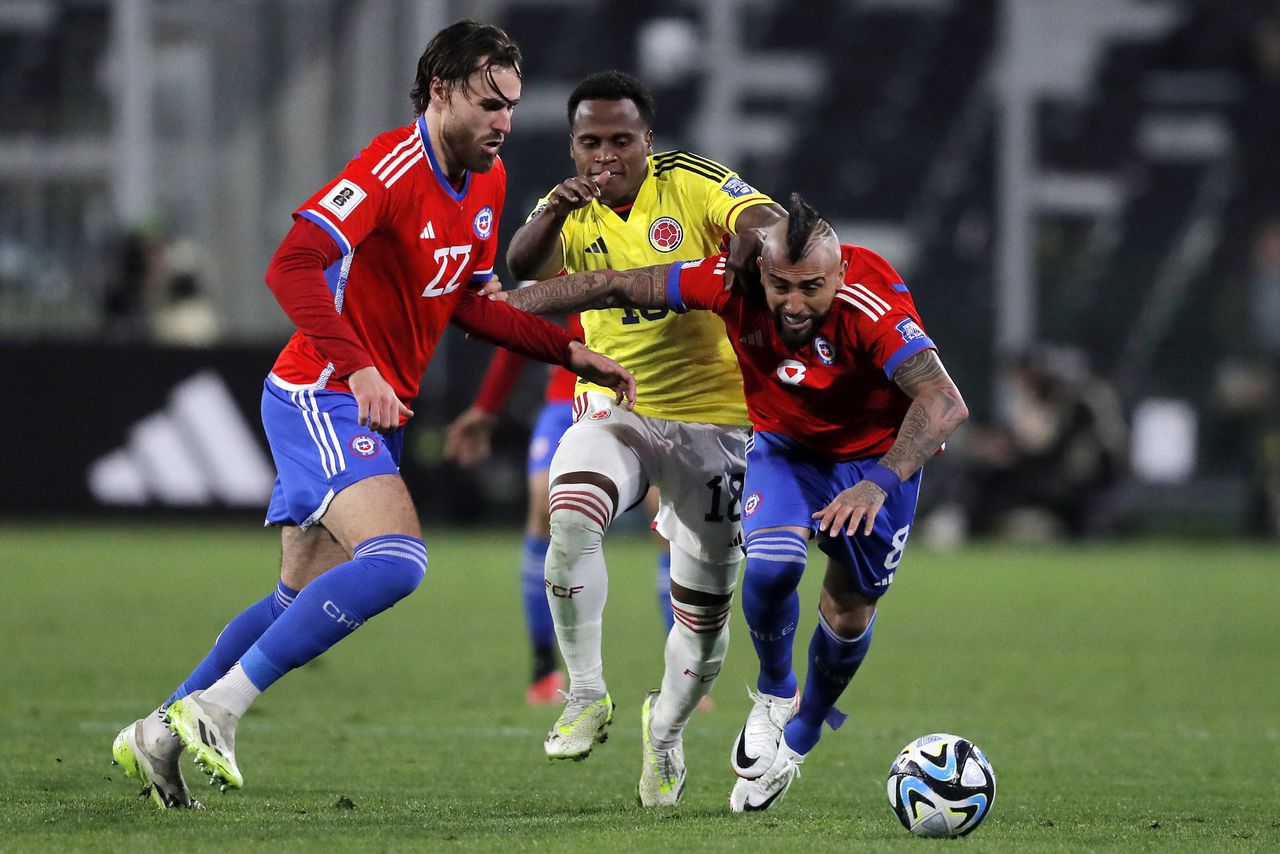 Colombia's midfielder Jhon Arias (C) fights for the ball with Chile's forward Ben Brereton (L) and midfielder Arturo Vidal during the 2026 FIFA World Cup South American qualifiers football match between Chile and Colombia, at the David Arellano Monumental stadium, in Santiago, on September 12, 2023. (Photo by Javier TORRES / AFP)