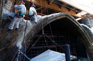Workmen plaster stonework as they rappel down a vault at the reconstruction site of the Notre-Dame de Paris cathedral, Thursday April 15, 2021. Two years after a fire tore through Paris' most famous cathedral and shocked the world, French President Emmanuel Macron on Thursday visited the building site that Notre Dame has become to show that French heritage has not been forgotten despite the coronavirus. (Ian Langsdon, Pool via AP)