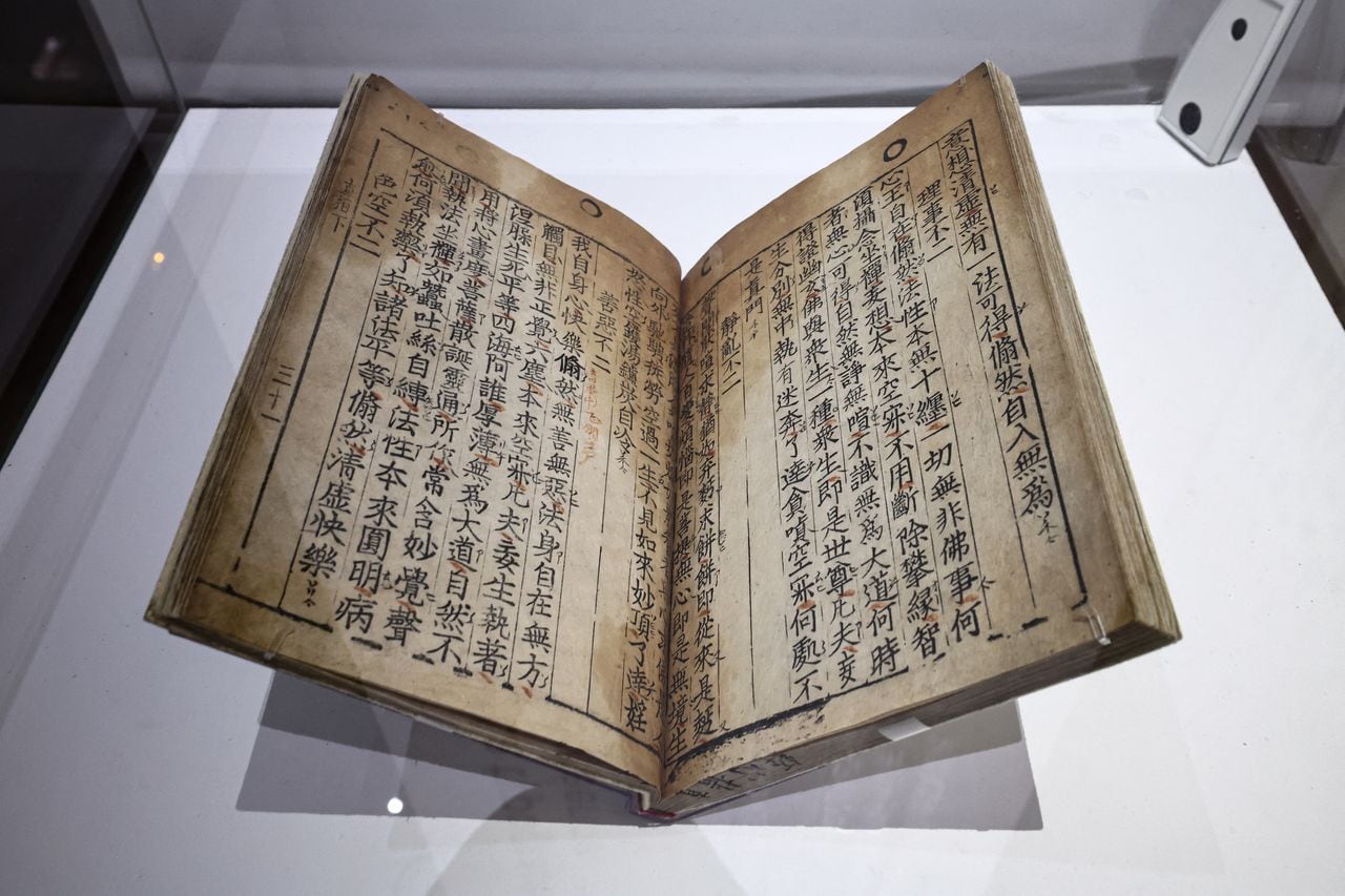 This photograph taken on April 12, 2023 in Paris, shows the Jikji, a Korean book dating from 1377 and "the first print from movable metal type still preserved" displayed as part of the exhibition "Print! Gutenberg's Europe at the Bibliotheque Francois Mitterand (BnF). - The oldest known work printed on a mechanical press -- a Korean book that predates the first European example by several decades -- went on display in Paris for the first time in 50 years on April 12, 2023. The "Jikji", a collection of Buddhist teachings, was printed in 1377 -- some 78 years before Johannes Gutenberg produced his famous Bible using his printing press in Germany. (Photo by Anne-Christine POUJOULAT / AFP)