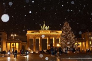 Un árbol de Navidad se ilumina frente a la Puerta de Brandenburgo durante una nevada en Berlín, Alemania