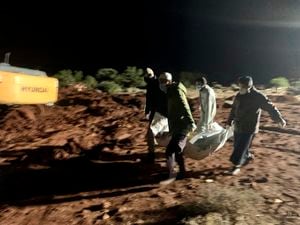 Los trabajadores entierran los cuerpos de las víctimas de las recientes inundaciones causadas por la tormenta mediterránea Daniel cerca de la ciudad de Derna, Libia, el martes 12 de septiembre de 2023 por la noche. (Foto AP/Yousef Murad)