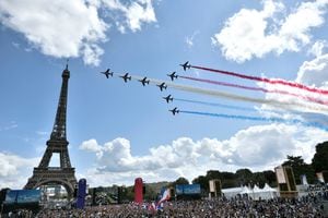 La patrulla aérea francesa 'Patrouille de France' sobrevuela la aldea de fans de El Trocadero frente a la Torre Eiffel, en París, el 8 de agosto de 2021 tras la transmisión de la ceremonia de clausura de los Juegos Olímpicos de Tokio 2020. (Foto de STEPHANE DE SAKUTIN / AFP)
