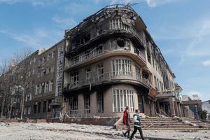 Los residentes caminan cerca de un edificio destruido en el curso del conflicto Ucrania-Rusia, en la ciudad portuaria sureña de Mariupol, Ucrania, 10 de abril de 2022. Foto REUTERS/Alexander Ermochenko.