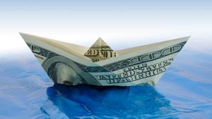 Barco de dólar de papel en el agua