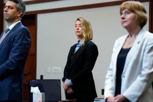 La actriz estadounidense Amber Heard (C) de pie en la sala del tribunal con su equipo legal en el Tribunal de Circuito del Condado de Fairfax, durante un caso de difamación en su contra por parte de su exesposo, el actor estadounidense Johnny Depp.