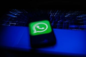 WhatsApp logo displayed on a phone screen and a laptop keyboard are seen in this long exposure illustration photo taken in Krakow, Poland on February 6, 2022. (Photo illustration by Jakub Porzycki/NurPhoto via Getty Images)