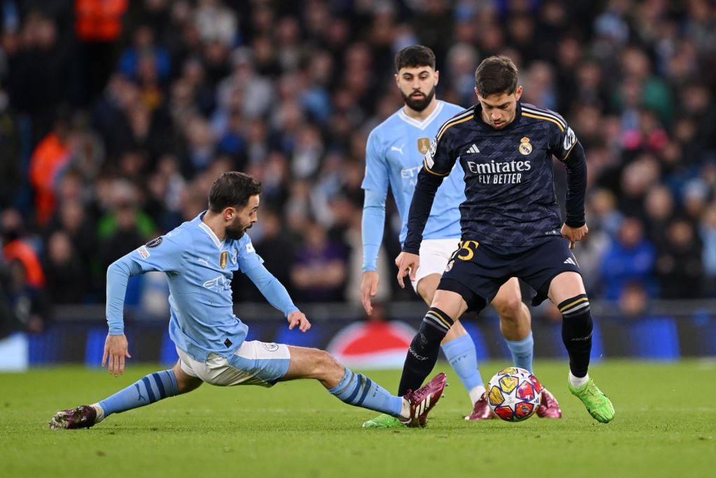 MANCHESTER, ENGLAND - APRIL 17: Federico Valverde of Real Madrid is challenged by Bernardo Silva of Manchester City during the UEFA Champions League quarter-final second leg match between Manchester City and Real Madrid CF at Etihad Stadium on April 17, 2024 in Manchester, England. (Photo by Stu Forster/Getty Images)