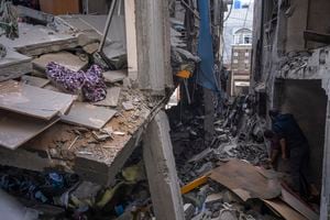 Los palestinos inspeccionan los daños a su edificio luego de los ataques aéreos israelíes contra la casa de un comandante de la Yihad Islámica en la ciudad de Gaza, el martes 9 de mayo de 2023.