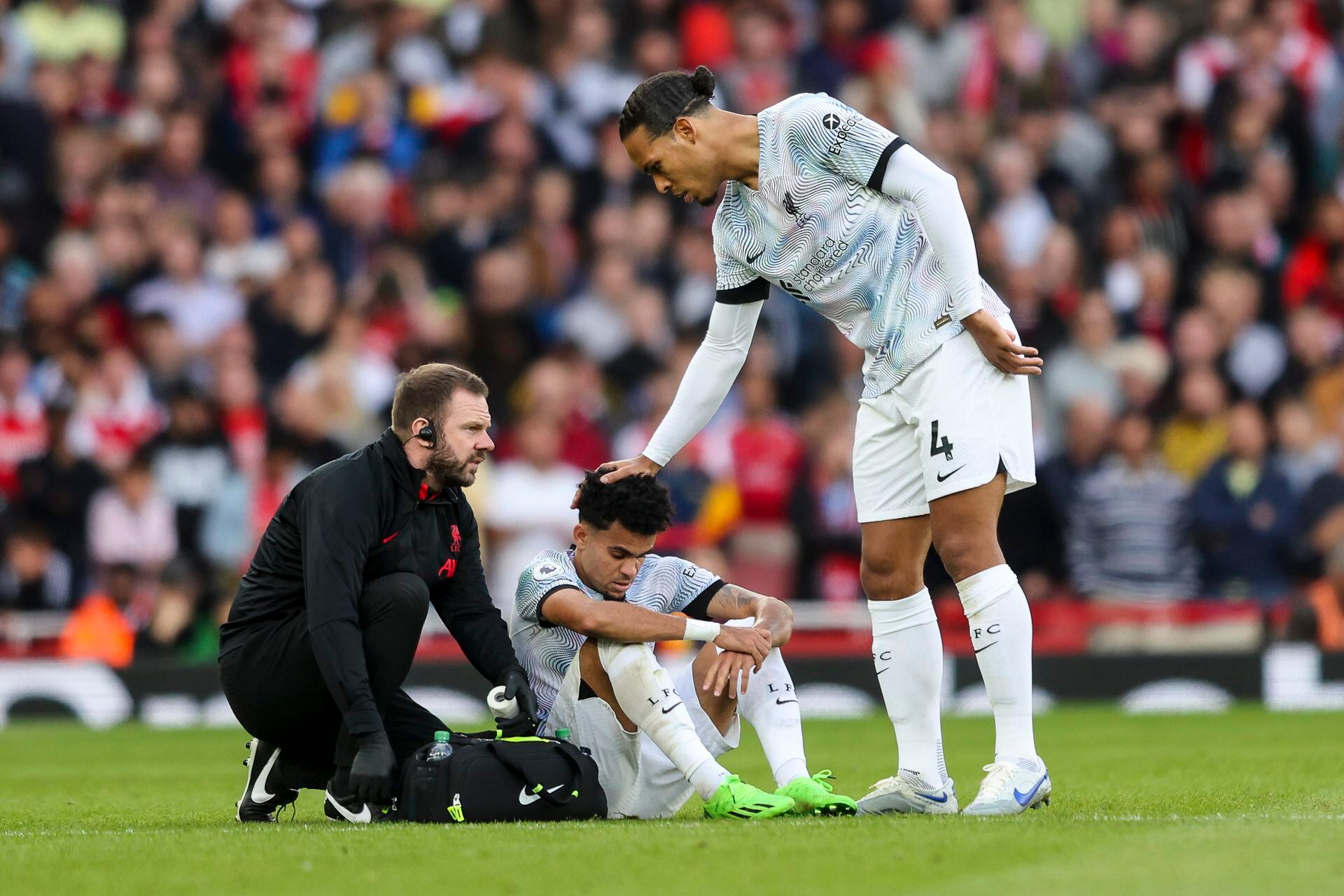 Luis Díaz recibe el apoyo de Virgil Van Dijk tras su lesión en el partido contra el Arsenal.