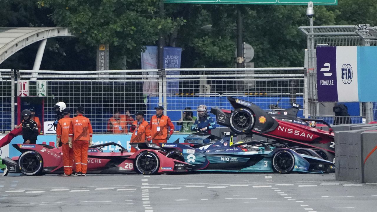 Track marshalls work near the cars of Avalanche Andretti Formula E's driver Oliver Askew of the U.S., 28, Nio 333 Formula E Team's driver Oliver Turvey of Britain, 3, and Nissan e.dams' driver Sebastien Buemi of Switzerland, 23, after they crashed during the Seoul E-Prix Formula E auto race round 15 in Seoul, South Korea, Saturday, Aug. 13, 2022. (AP Photo/Lee Jin-man)