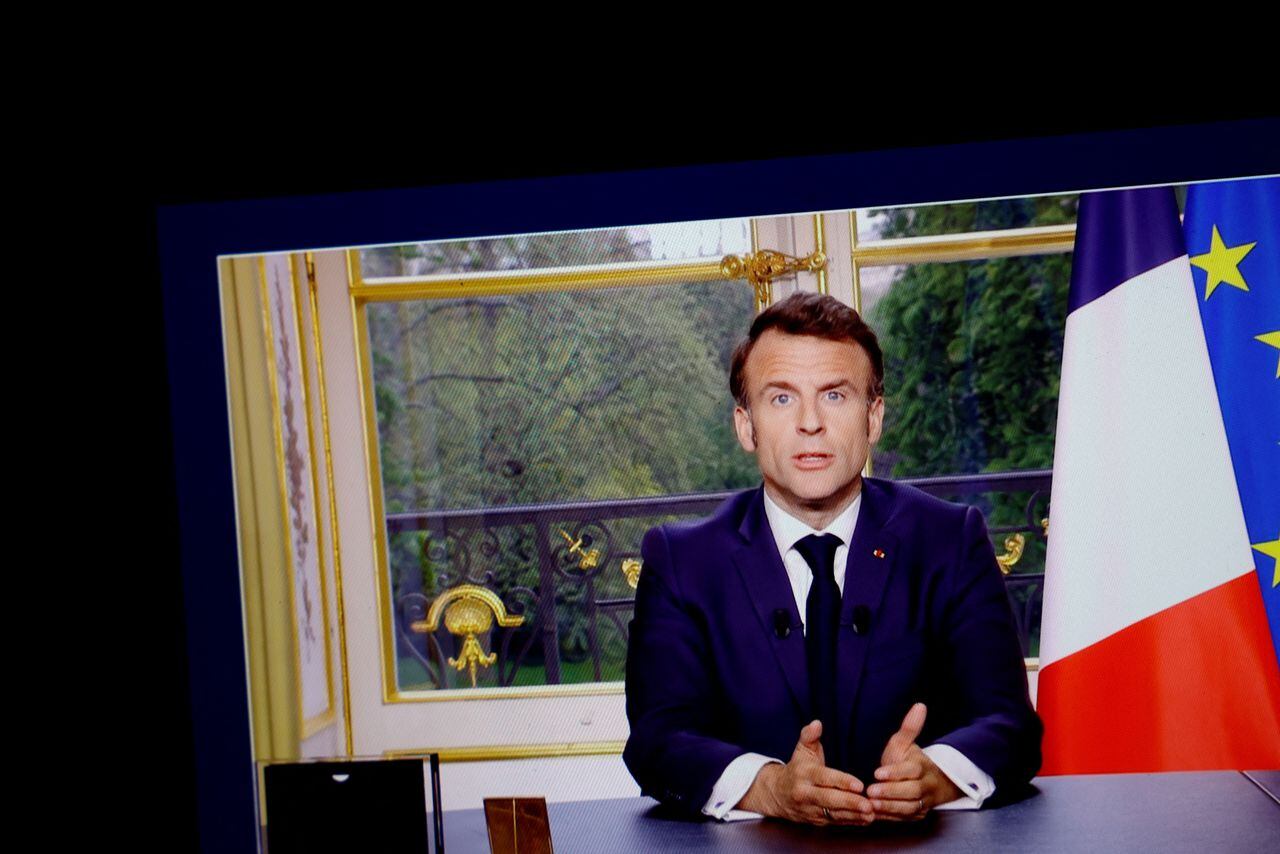 El presidente francés, Emmanuel Macron, aparece en una pantalla, mientras habla durante un discurso especial a la nación desde el Palacio del Elíseo