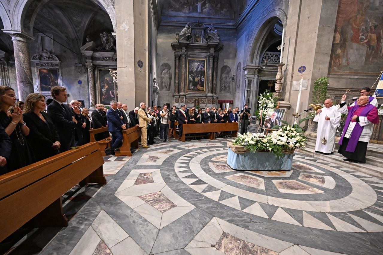 El sacerdote italiano Stefano D'Atri (R) bendice la urna que contiene las cenizas del artista colombiano Fernando Botero durante la ceremonia fúnebre, en la catedral central de la ciudad de Pietrasanta, en la región de Toscana, el 7 de octubre de 2023. (Foto de Andreas SOLARO / AFP)