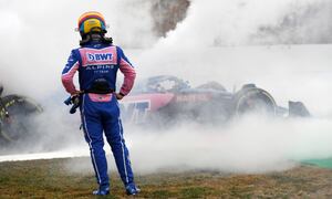 Alpine driver Fernando Alonso of Spain watches smoke pour from his car during a Formula One pre-season testing session at the Catalunya racetrack in Montmelo, just outside of Barcelona, Spain, Friday, Feb. 25, 2022. (AP Photo/Joan Monfort)