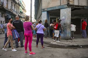 En medio de un pesado sol, cubanos se mantienen en las filas para acceder a bienes básicos. (Photo by Yamil LAGE / AFP)