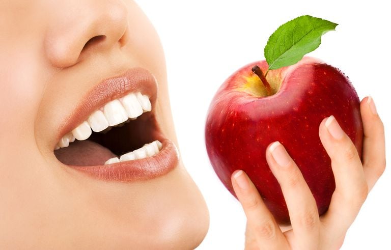 Los dientes de una mujer y una manzana