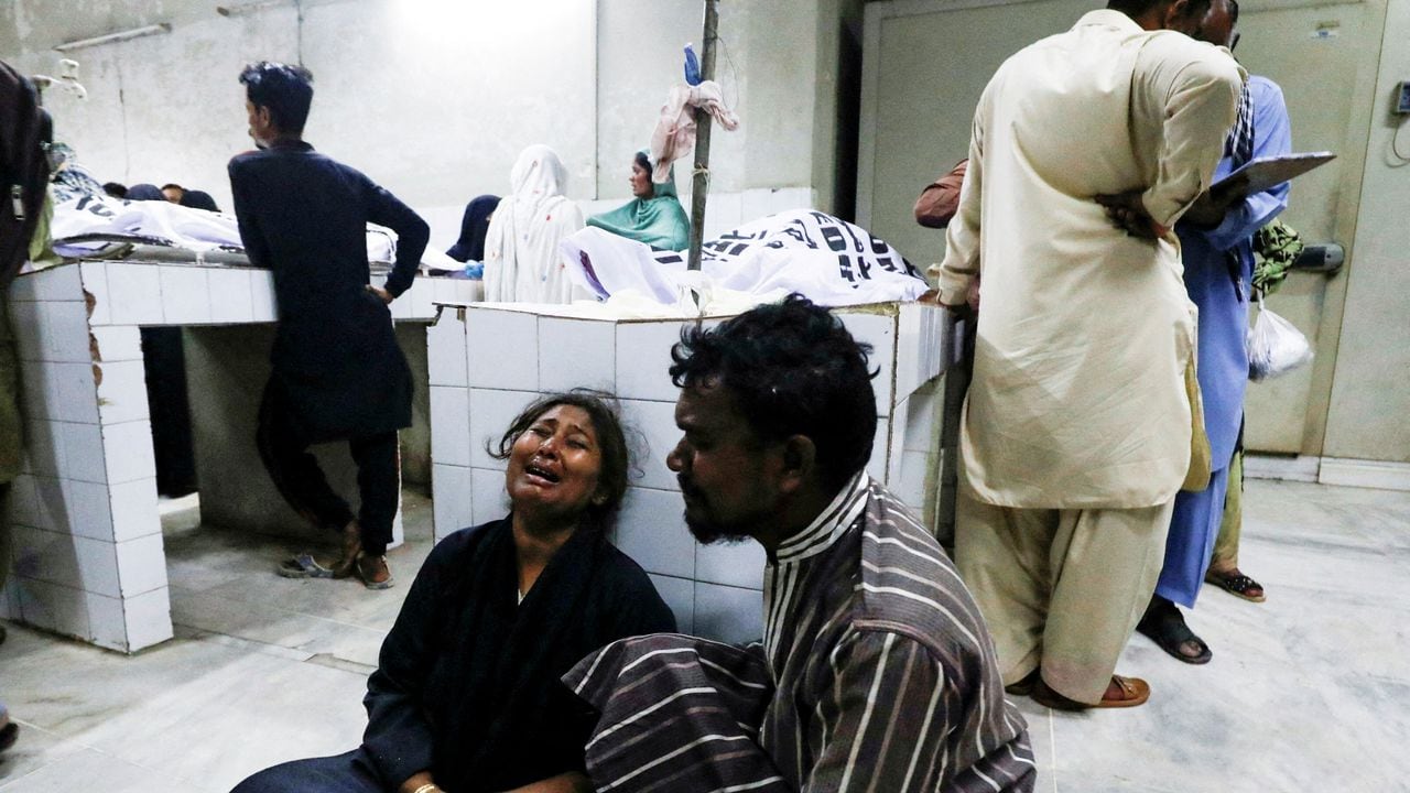 La gente llora la muerte de un pariente, que fue asesinado junto con otros en una estampida durante la distribución de folletos y comida en la morgue de un hospital en Karachi, Pakistán