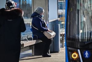 Una mujer con mascarilla espera un autobús en una parada de autobús en el centro de Moscú el 21 de octubre de 2021. - Rusia registró oficialmente 37 930 casos de coronavirus el 25 de octubre. Moscú cerrará los servicios no esenciales entre el 28 de octubre y el 7 de noviembre. El presidente ruso, Vladimir Putin, ordenó una semana libre pagada a nivel nacional a partir del 30 de octubre para frenar la rápida propagación de infecciones. (Foto de Yuri KADOBNOV / AFP)