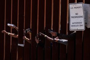 Los migrantes esperan que los trabajadores humanitarios carguen sus teléfonos mientras esperan entre las cercas fronterizas primaria y secundaria mientras Estados Unidos se prepara para levantar las restricciones del Título 42 de la era COVID-19 que han impedido que los migrantes en la frontera entre Estados Unidos y México busquen asilo desde 2020. cerca de San Diego, California, EE.UU., 11 de mayo de 2023. 