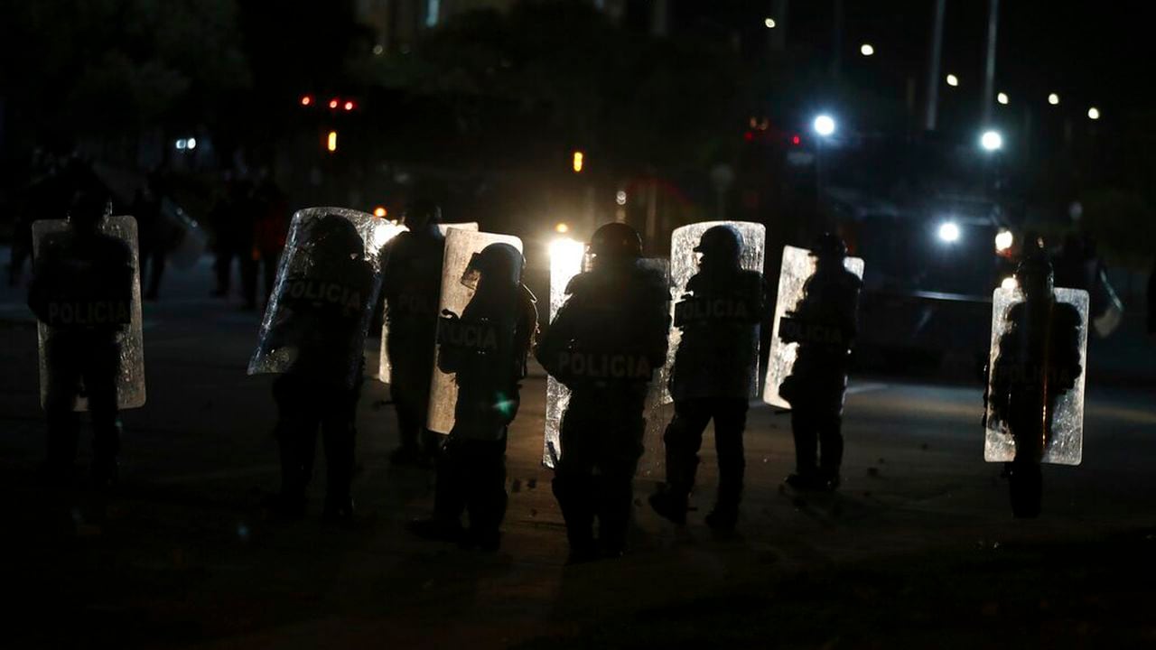 Riot police hold their shields close to a bus station during an anti-government protest in Bogota, Colombia, Thursday, May 20, 2021. Colombians have taken to the streets for weeks across the country after the government proposed tax increases on public services, fuel, wages and pensions. (AP Photo/Fernando Vergara)