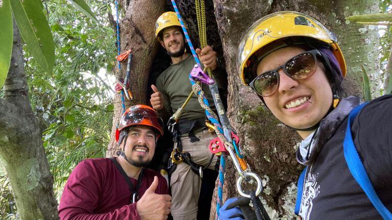 Mateo Giraldo, Ana María Morales y Luis Felipe Barrera, escalando un árbol para instalar cámaras trampas.