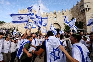 Los israelíes cantan y bailan con banderas en la puerta de Damasco a la ciudad vieja de Jerusalén mientras conmemoran el día de Jerusalén, en Jerusalén el 18 de mayo de 2023. 