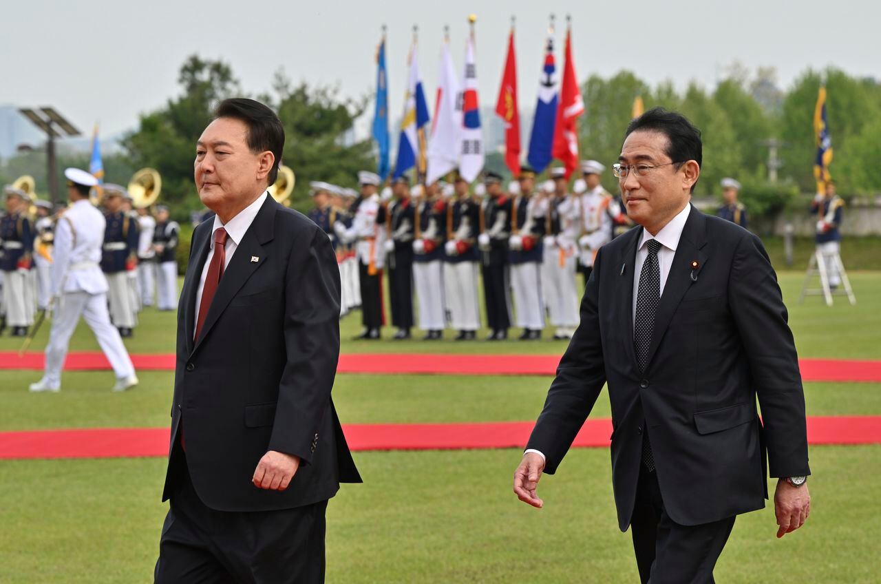 El primer ministro de Japón, Fumio Kishida, a la derecha, y el presidente de Corea del Sur, Yoon Suk Yeol, asisten a una ceremonia de bienvenida en la oficina presidencial en Seúl, el domingo 7 de mayo de 2023. (Jung Yeon-je/Pool Foto via AP)