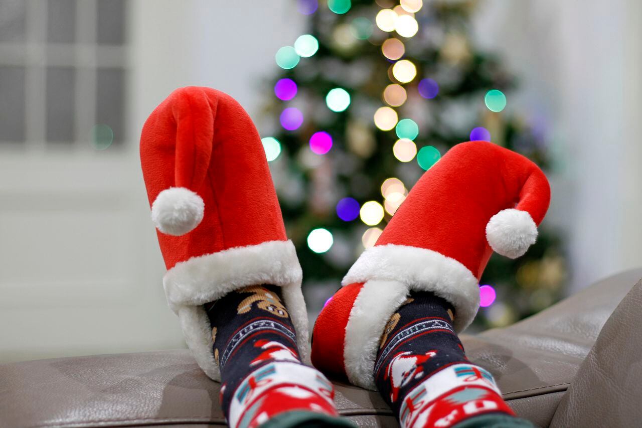 Legs with Xmas slippers on sofa