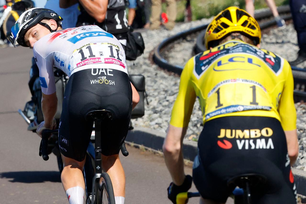 UAE Team Emirates' Slovenian rider Tadej Pogacar (L) wearing the best young rider's white jersey cycles ahead of Jumbo-Visma's Danish rider Jonas Vingegaard (R) wearing the overall leader's yellow jersey in the ascent of the Puy de Dome in the final kilometers of the 9th stage of the 110th edition of the Tour de France cycling race, 182,5 km between Saint-Leonard-de-Noblat and Puy de Dome, in the Massif Central volcanic mountains in central France, on July 9, 2023. (Photo by Etienne GARNIER / POOL / AFP)