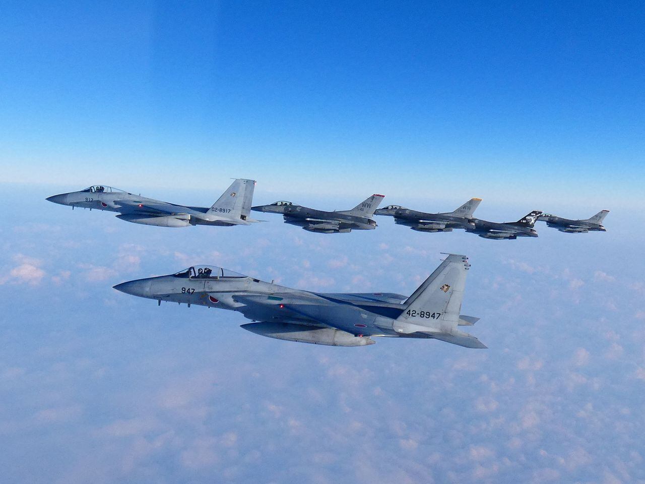 Los cazas F-15 de la 2.ª Ala Aérea de la Fuerza de Autodefensa Aérea de Japón realizan un simulacro militar conjunto con los cazas F-16 de EE. UU. en el Mar de Japón, frente a la isla principal más al sur de Japón