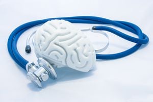 El modelo de cerebro humano con circunvoluciones y estetoscopio azul están sobre fondo blanco uniforme. Concepto de salud fotográfica o condición patológica del cerebro humano, diagnóstico de enfermedades del sistema nervioso