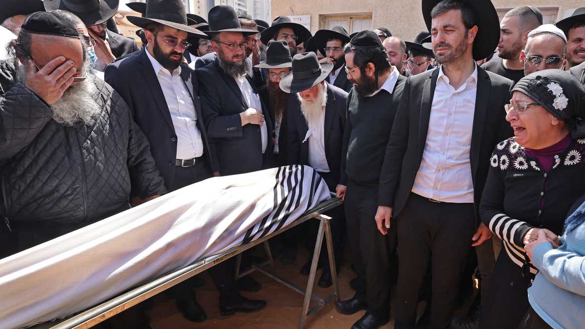 Los dolientes israelíes asisten al funeral de Avishai Yehezkel, una de las cinco personas que murieron en el tiroteo de ayer en la ciudad religiosa de Bnei Brak, el 30 de marzo de 2022. - El primer ministro israelí, Naftali Bennett, advirtió sobre una "ola del terrorismo árabe asesino" antes de los funerales de dos de las cinco personas muertas en un tiroteo en la ciudad judía ultrarreligiosa. El tiroteo en Bnei Brak, una ciudad costera en las afueras de Tel Aviv, de cuatro civiles y un oficial de policía fue el tercer ataque fatal con arma o cuchillo en el estado judío en la última semana. (Foto de Menahem KAHANA / AFP)