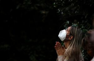 A woman attends Mass outside the Schoenstatt shrine during Easter in Buenos Aires, Argentina, Thursday, April 1, 2021. The Mass was held outside to avoid the spreading of COVID-19. (AP Photo/Natacha Pisarenko)