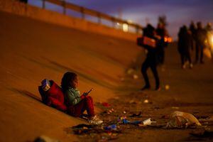 Una niña migrante de Venezuela, que viaja con su familia en busca de asilo, se sienta a orillas del río Bravo, la frontera entre Estados Unidos y México, en Ciudad Juárez, México, 20 de diciembre de 2022. 